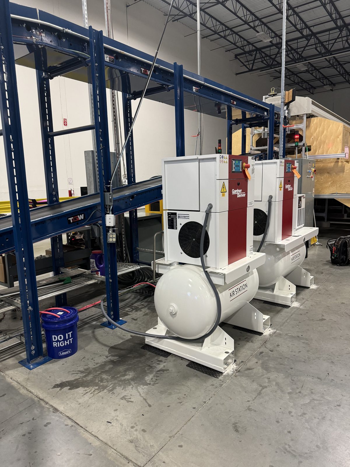 Two compressors mounted on structural racking above the plant floor