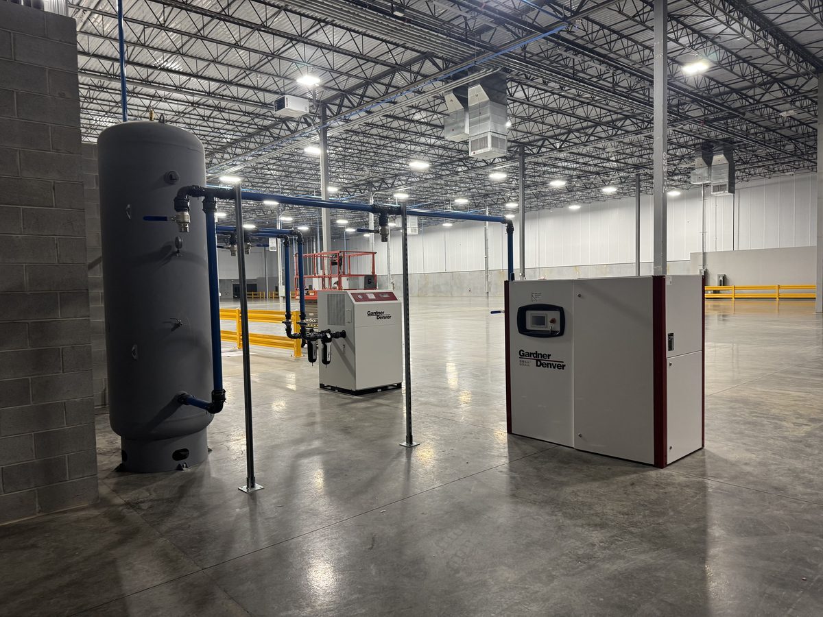 Industrial rotary screw air compressor system and process piping installed in a manufacturing plant