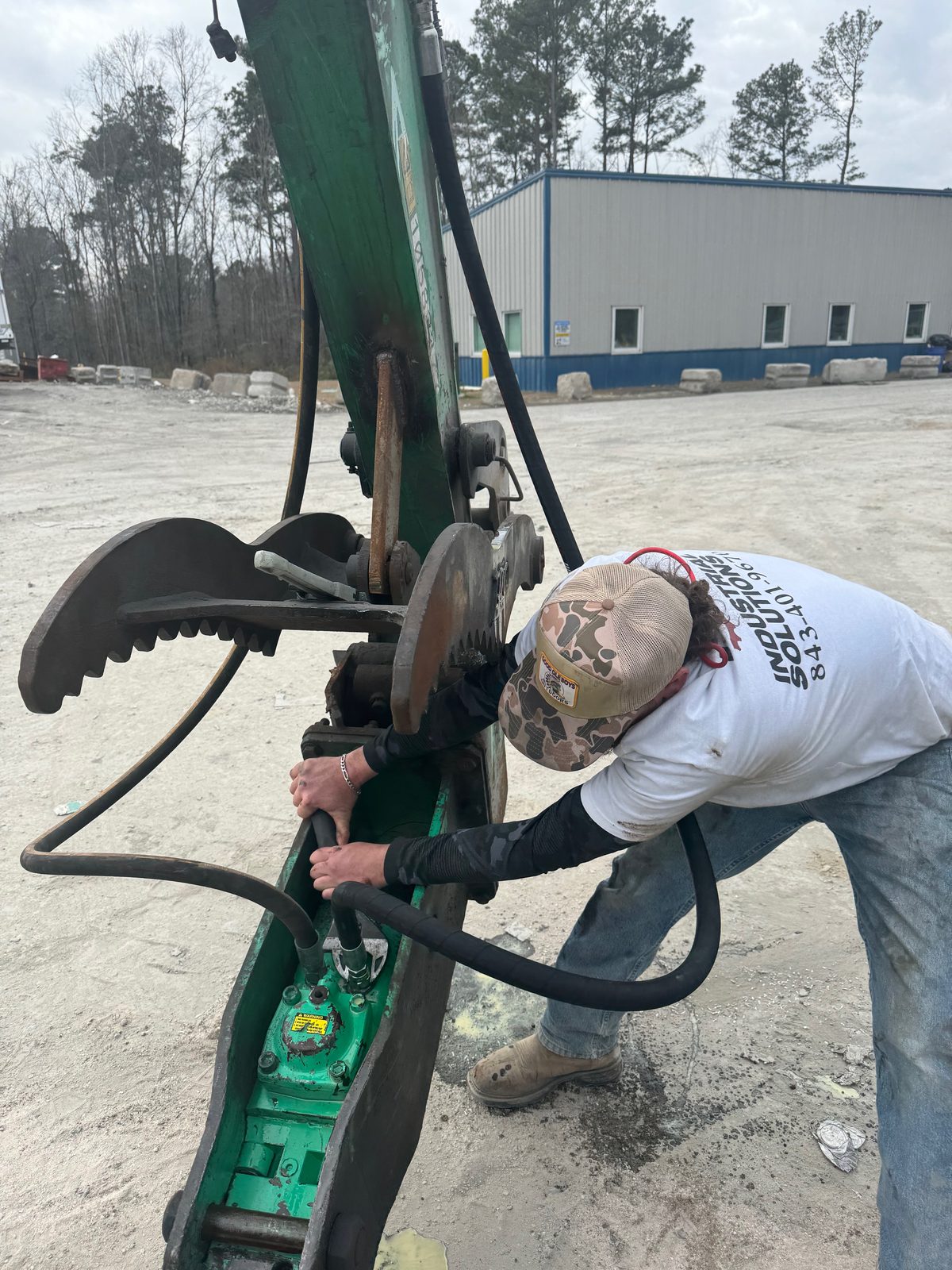 Technician carrying out a hydraulic repair on heavy equipment in the field