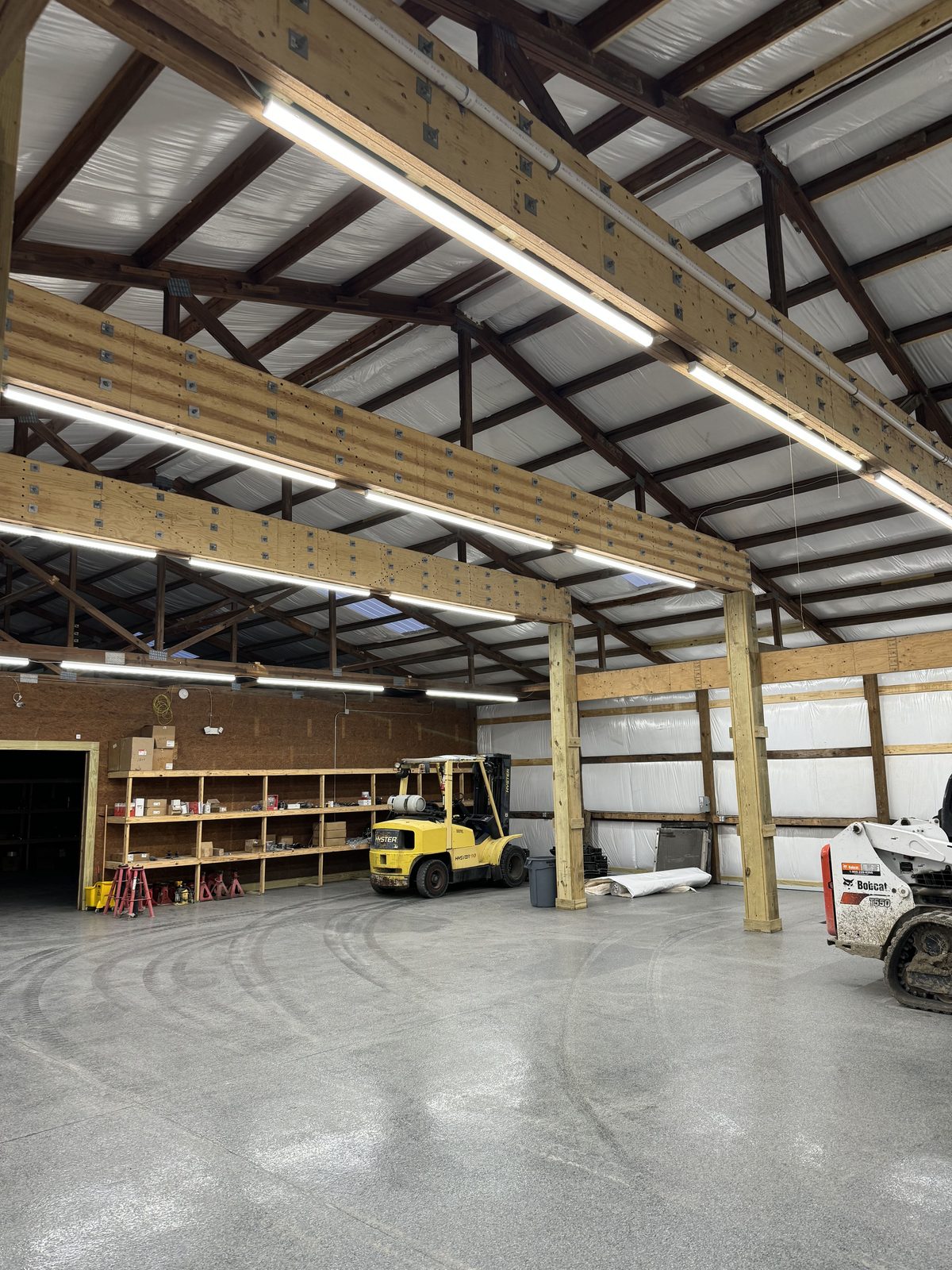 Overhead compressed air lines and lighting installed through a warehouse